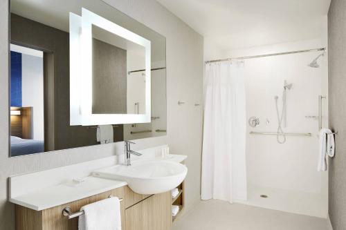 a white bathroom with a sink and a shower at SpringHill Suites by Marriott Springfield North in Springfield