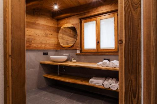 a bathroom with a sink and a mirror and towels at Locanda Il Campo della Quercia in San Damiano Macra