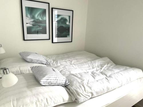 a bed in a room with three pictures on the wall at AURORA in Lübeck