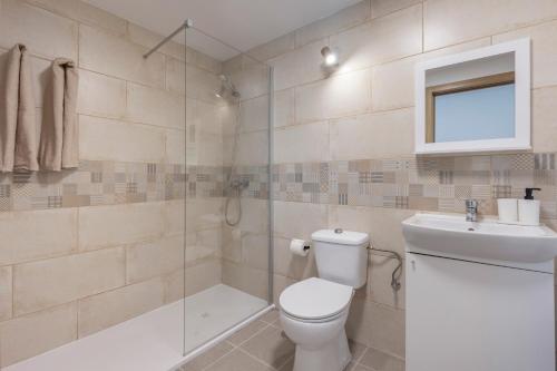 a bathroom with a toilet and a sink and a shower at Casa Muley in El Matorral