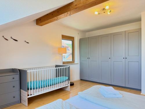 a baby room with a crib and a bed at Ferienwohnung Wohlfühloase - gemütliche Familienunterkunft in ruhiger Lage in Achberg