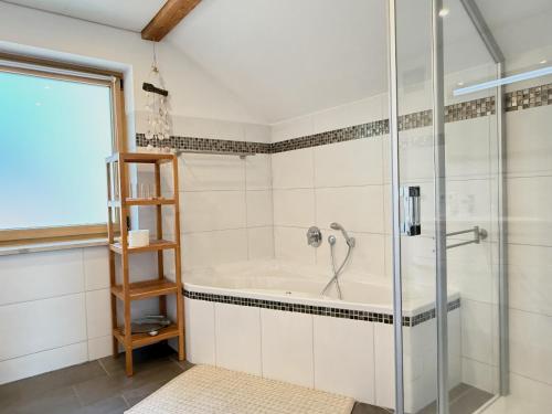 a bathroom with a shower and a tub at Ferienwohnung Wohlfühloase - gemütliche Familienunterkunft in ruhiger Lage in Achberg