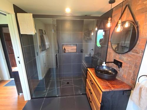 a bathroom with a sink and a shower at Luxe Tiny Home in Whangarei
