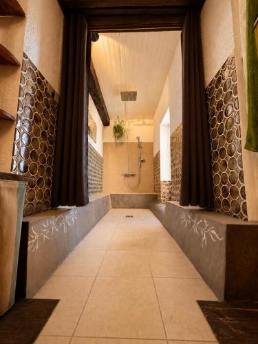 a large bathroom with a shower and a tile floor at La chambre la Tricherie in Crastes