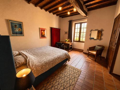 a bedroom with a bed and a desk and a window at La chambre la Tricherie in Crastes