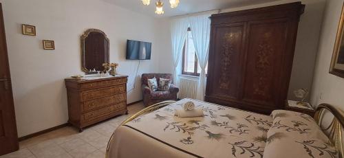ein Schlafzimmer mit einem Bett, einer Kommode und einem Stuhl in der Unterkunft Locanda Rum e Pera in Acquapendente