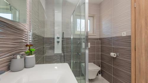 a bathroom with a toilet and a glass shower at Villa Ivandvor in Split by Villas Guide in Radošić