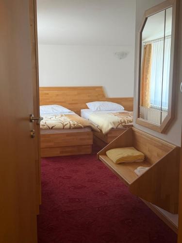 two beds in a room with a mirror at Hotel Finida in Obrov