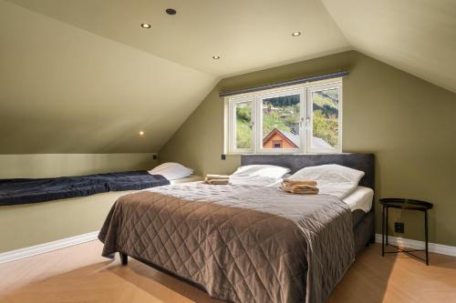 a attic bedroom with two beds and a window at Trolltunga Stay - Mountain & Waterfall View in Odda