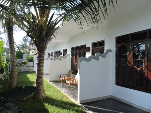 une maison avec un palmier dans la cour dans l'établissement Seadina Coral Home, à Matara