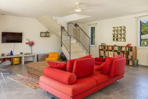 a living room with a red couch and a staircase at Villa Santa Mara Poggio in Santa-Maria-Poggio
