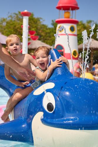 two young children riding on a blue submarine in the water at RCN Vakantiepark Toppershoedje in Ouddorp