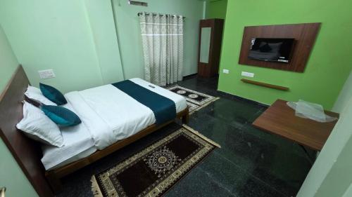a bedroom with a bed and a tv in a room at Tree Top Residency in Mysore