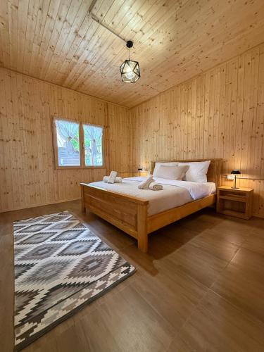 a bedroom with a bed in a wooden room at Shpija Ujevara e Vogel 2 in Theth