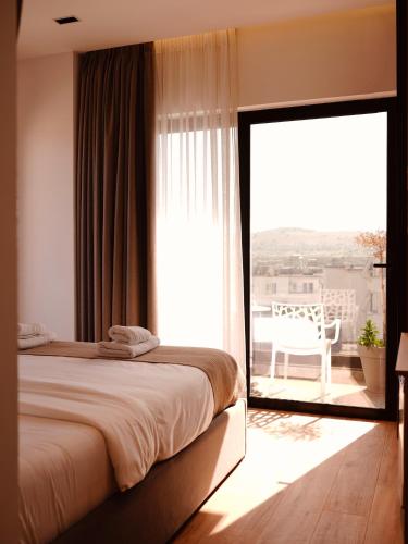 a bedroom with a bed and a large glass window at Foga Aus in Ksamil