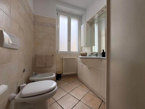 a white bathroom with a toilet and a sink at Lake Como - Casa Mafy in Bellano