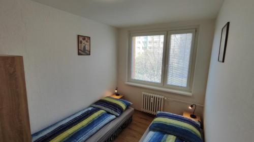 a bedroom with two beds and a window at Apartmán pro 4 osoby, Most M1 in Most