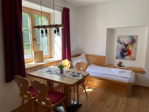 a room with a bed and a table and a window at Der Waidachhof Zillertal in Hainzenberg