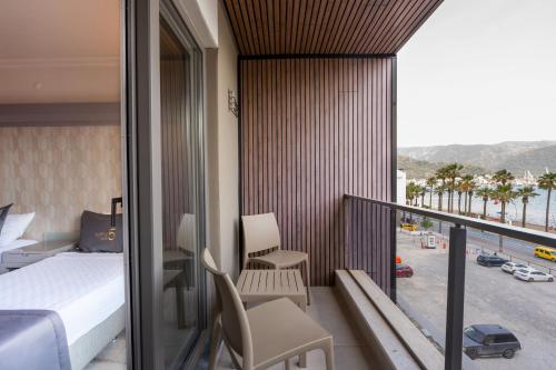 a bedroom with a bed and a balcony with a view at FIFTY5 Suite Hotel in Marmaris
