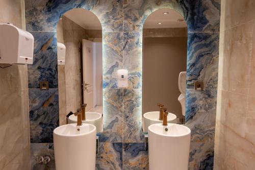 a bathroom with three sinks and two mirrors at FIFTY5 Suite Hotel in Marmaris