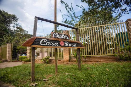 a sign for a cocacolaoked restaurant in the grass at Chalés Casa Rosa in Alto Paraíso de Goiás