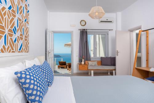 a bedroom with a bed and a view of the ocean at Gizis Cliffside Suites in Imerovigli