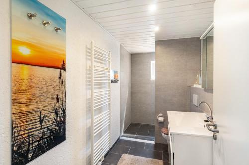 a bathroom with a sink and a painting on the wall at Ferienwohnung Koje 1 in Wangerland