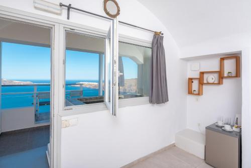 a room with a window with a view of the ocean at Gizis Cliffside Suites in Imerovigli