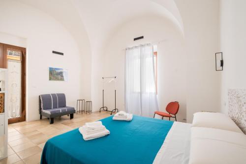 a bedroom with a blue bed with two towels on it at L'Angolo Del Teatro in Galatone