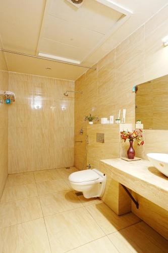 a bathroom with a toilet and a sink at Central boutique hotel in Morādābād