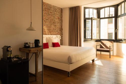 a hotel room with a bed and a chair at 9Hotel Central in Brussels