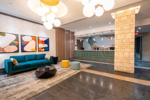 a lobby with a blue couch and a table at Sandman Suites Vancouver on Davie in Vancouver