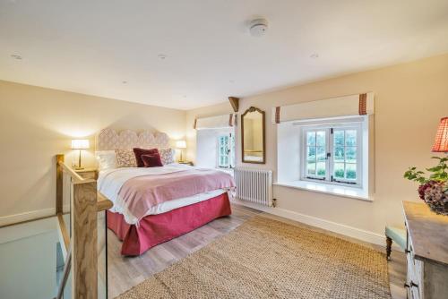 a bedroom with a large bed and a window at Piddle Cottage in Dorchester