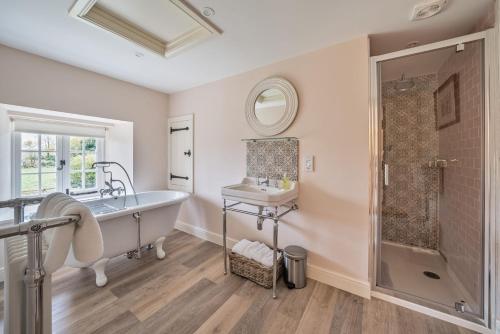 a bathroom with a tub and a sink at Piddle Cottage in Dorchester