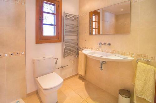 a bathroom with a toilet and a sink and a mirror at Villa Calma by Mallorca Infinity in Santa Ponsa