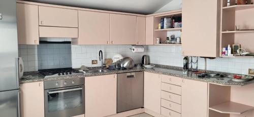 a kitchen with white cabinets and stainless steel appliances at Casa Théméo - Centro città Verbania Intra in Verbania
