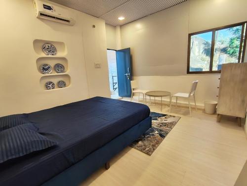 a bedroom with a bed and a table and chairs at Kiki Cottage in Mount Ābu