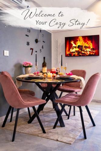 a dining room table with pink chairs and a fireplace at Aura Luxury Suites Bled in Bled