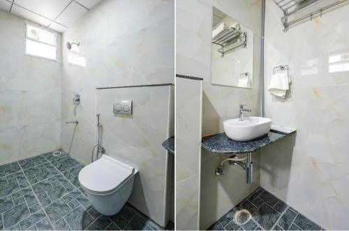 a white bathroom with a toilet and a sink at Hotel Vihara Inn in Bangalore