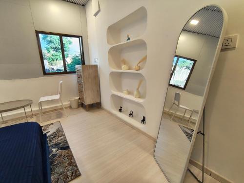 a room with a mirror and a table and chairs at Kiki Cottage in Mount Ābu