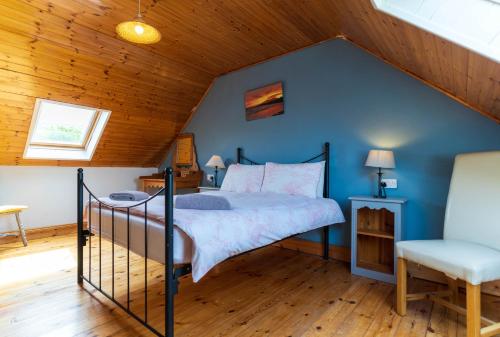 a bedroom with a bed and a blue wall at Blasket Cottage - Portmagee in Lateeve