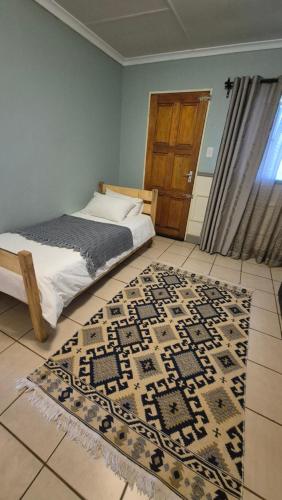 a bedroom with a bed and a rug on the floor at Herberg 5 in Vosburg