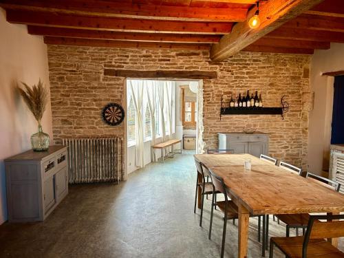 a dining room with a wooden table and chairs at Le Refuge Bourguignon in Nuits-Saint-Georges