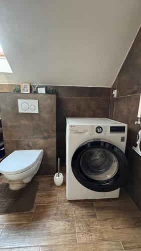 a washing machine in a bathroom with a toilet at Apartmán Noel in Soľ