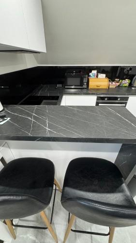 a black counter with two chairs at a desk at Apartmán Noel in Soľ