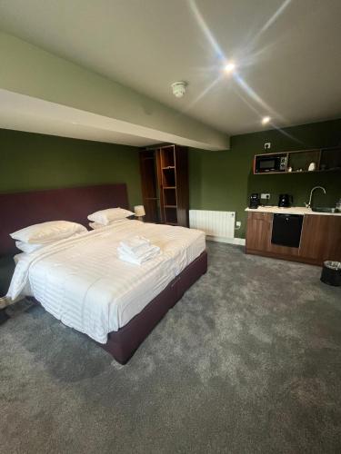 a bedroom with a large bed and a kitchen at The Gables in Carland