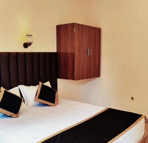a bedroom with a large bed with a wooden cabinet at Sahil villa in Alibaug