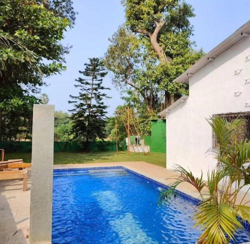 a swimming pool in front of a house at Sahil villa in Alibaug