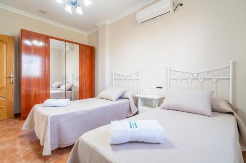a bedroom with two beds with white sheets at Cubo's Casa La Peña in Antequera