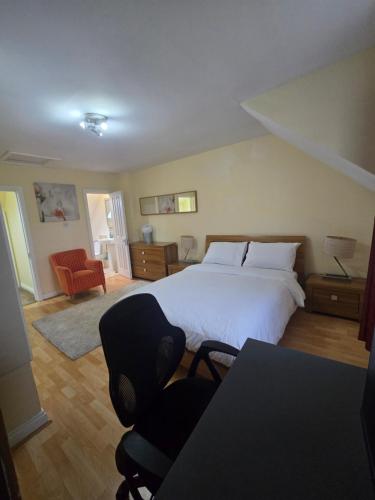 a bedroom with a bed and a desk and chairs at Gracian OMB Ongar 3 Bed in Dublin